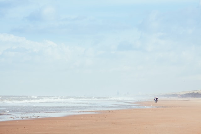 Vastgelopen graafmachine op Noordwijks strand na twee dagen op het droge getrokken